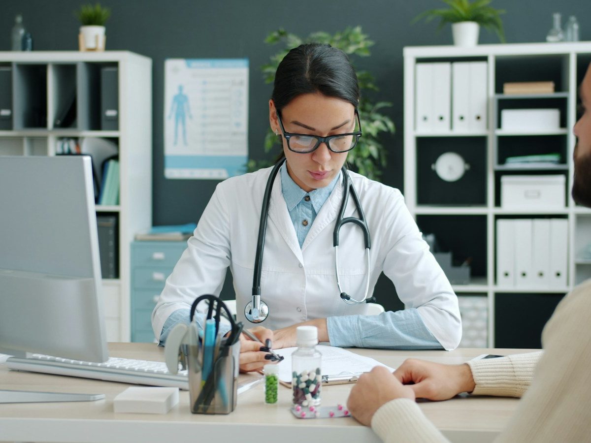 A doctor consulting with a patient at a desk